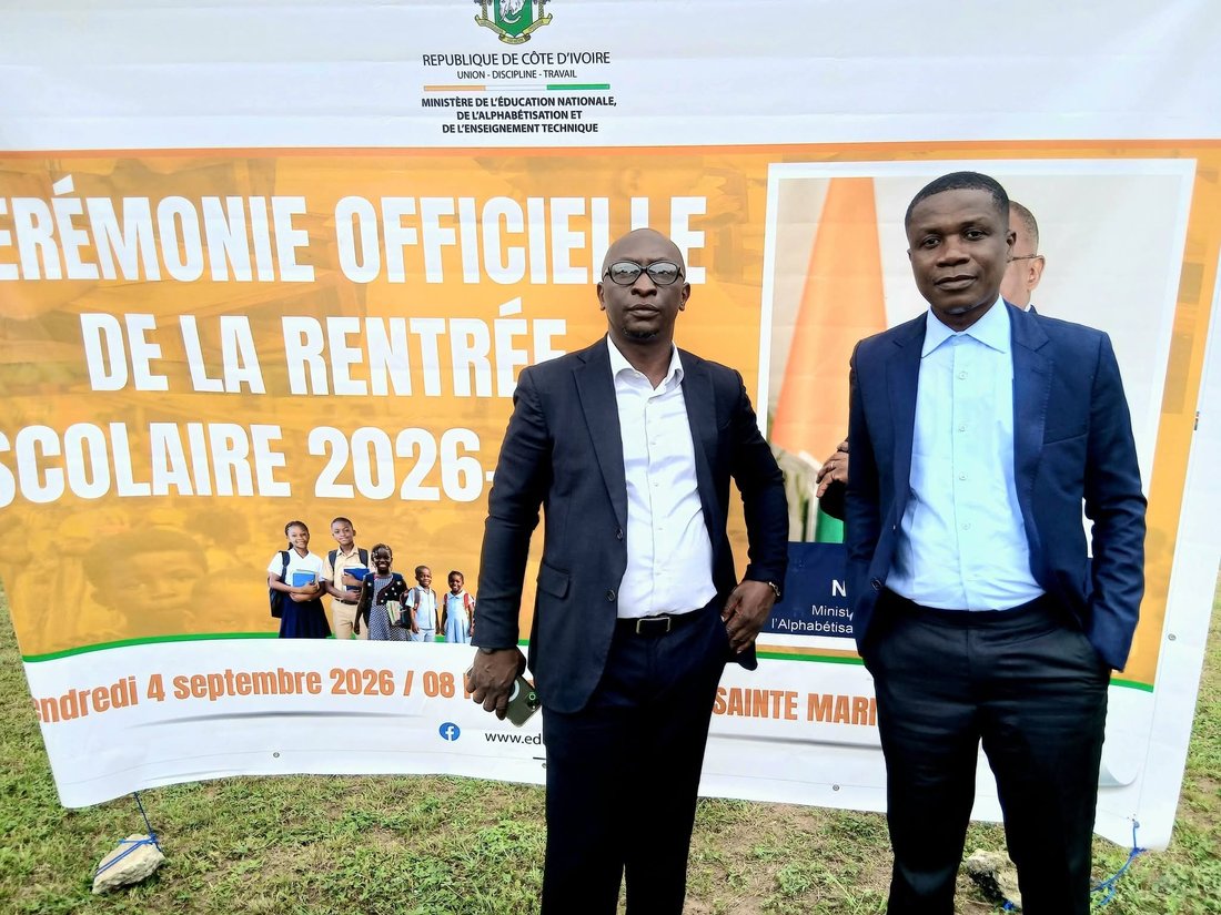 Enzah Samy Trha'o-rhey, Secrétaire Général Adjoint (à gauche), et Ghislain Duggary Assy, Secrétaire National chargé de la Communication (à droite), devant la banderole officielle de la rentrée scolaire 2026-2027